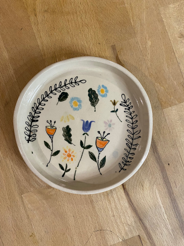 Ceramic bowl with floral designs on a wooden surface