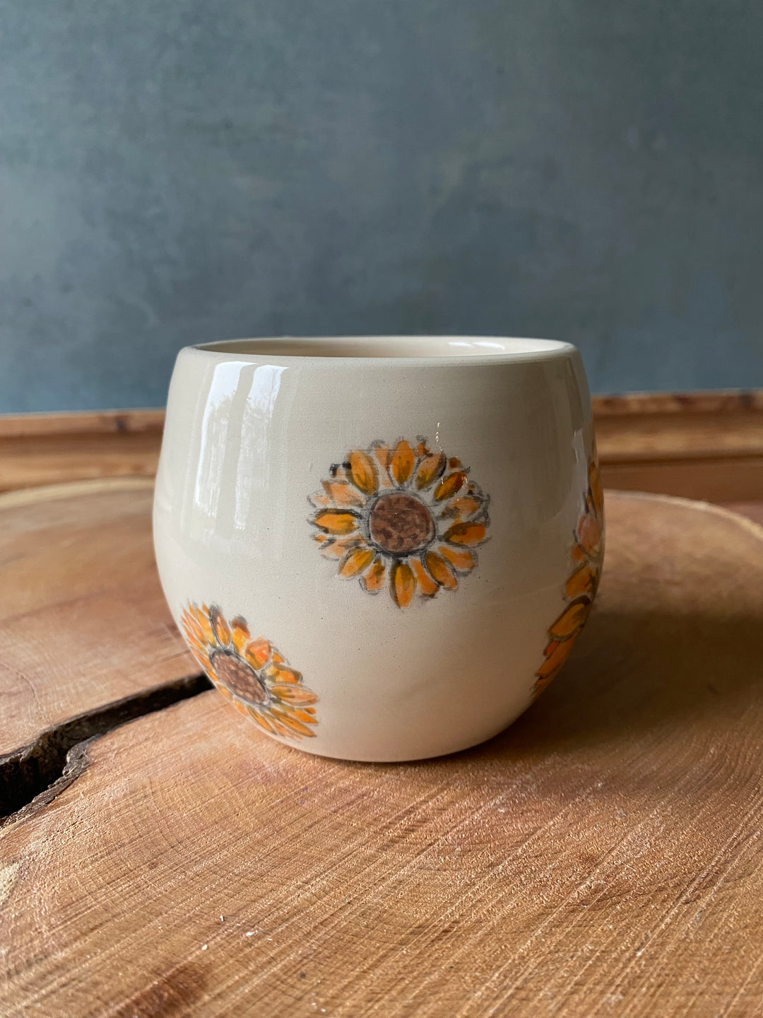 Ceramic mug with floral design on a wooden surface
