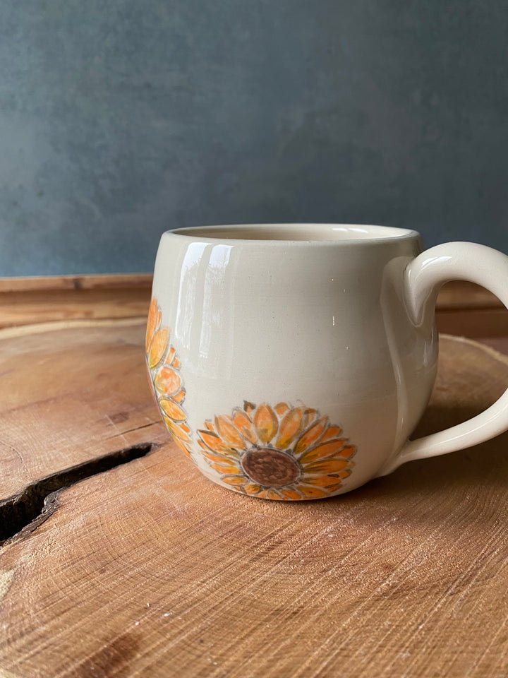 Ceramic mug with floral design on a wooden surface