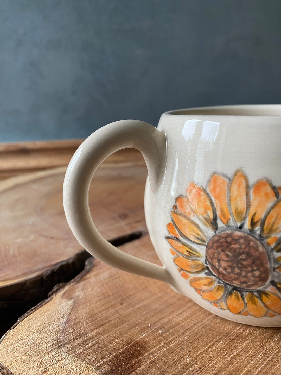 Mug with sunflower design on a wooden surface