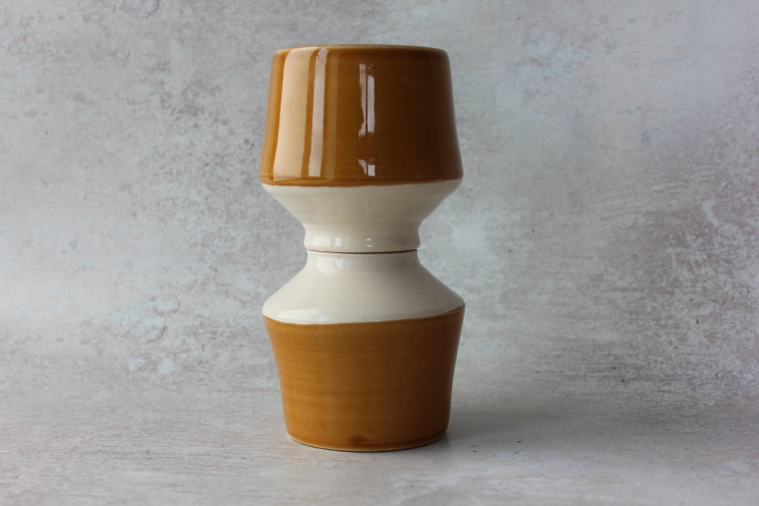 Honey caramel ceramic pedestal mug showing clear interior glaze and trimmed base