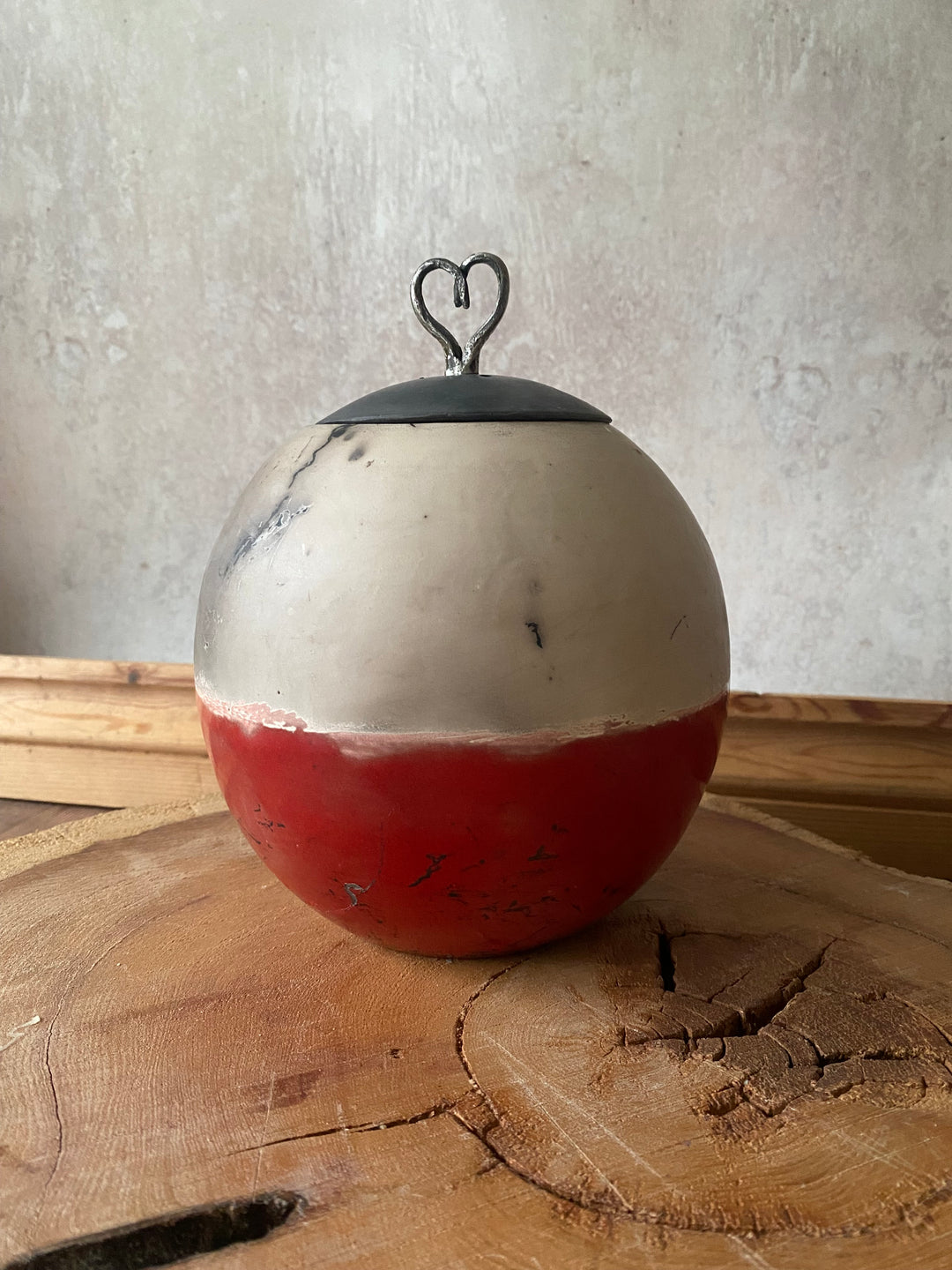 Red and white fishing float on a wooden surface