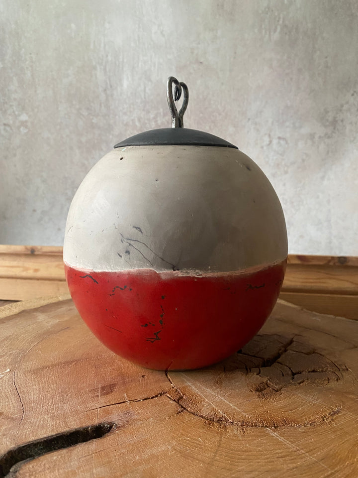 Red and white fishing float on a wooden surface