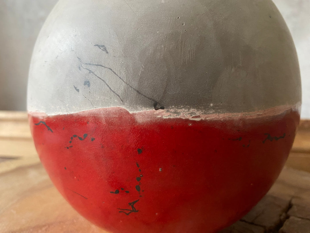 Balls with one half gray and one half red on a wooden surface