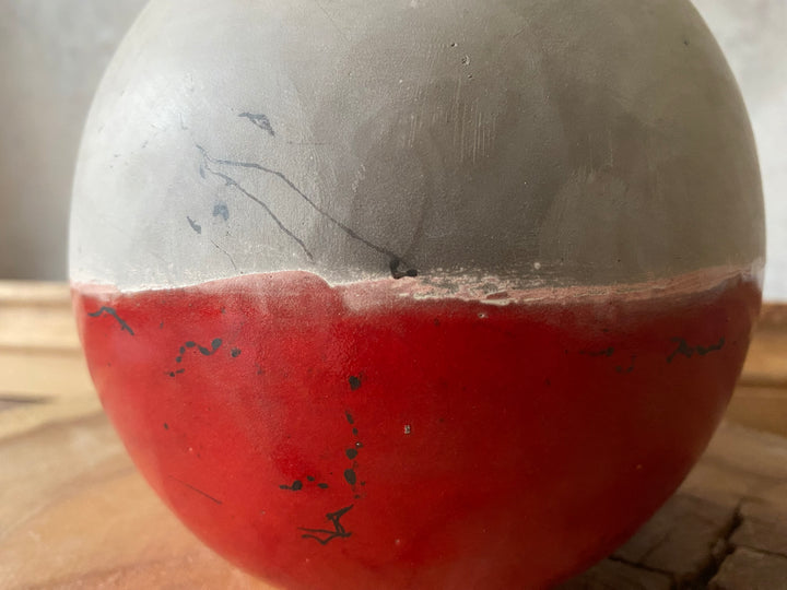 Balls with one half gray and one half red on a wooden surface