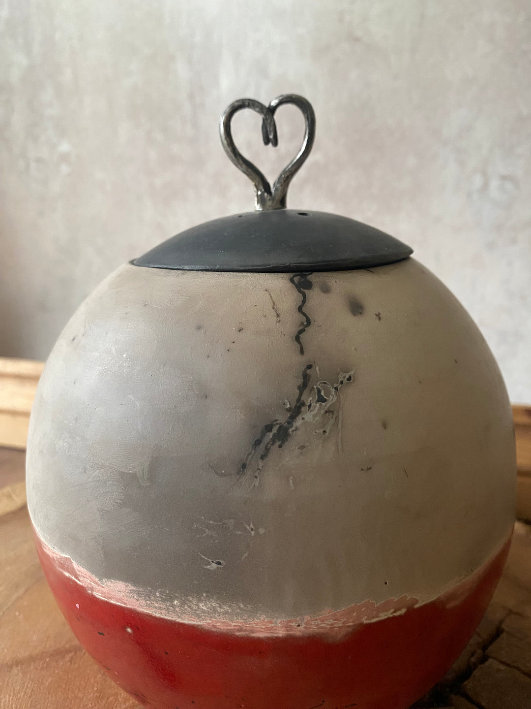 Close-up of a decorative item with a black heart-shaped ornament on a light background