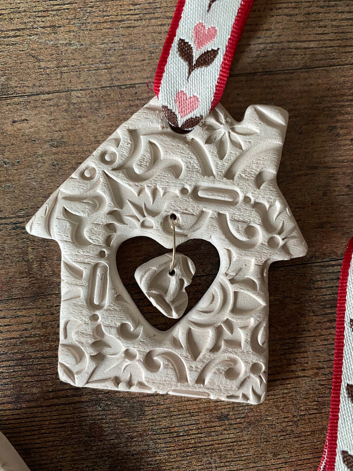Decorative white heart-shaped object with a black heart cutout on a wooden surface