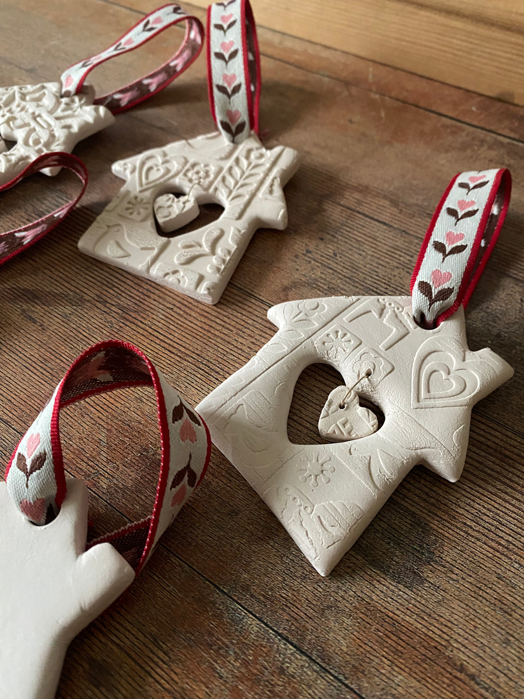 Decorative ceramic birdhouses with red ribbon on a wooden surface