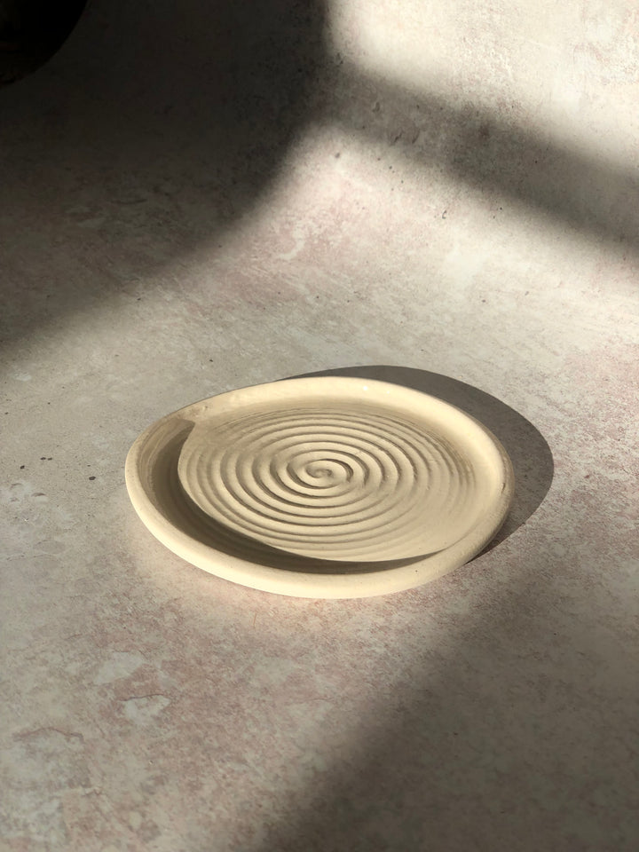 Round ceramic product with spiral design on a gray surface