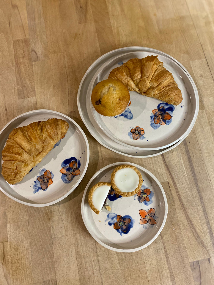 Three small plates with pastries on a wooden surface