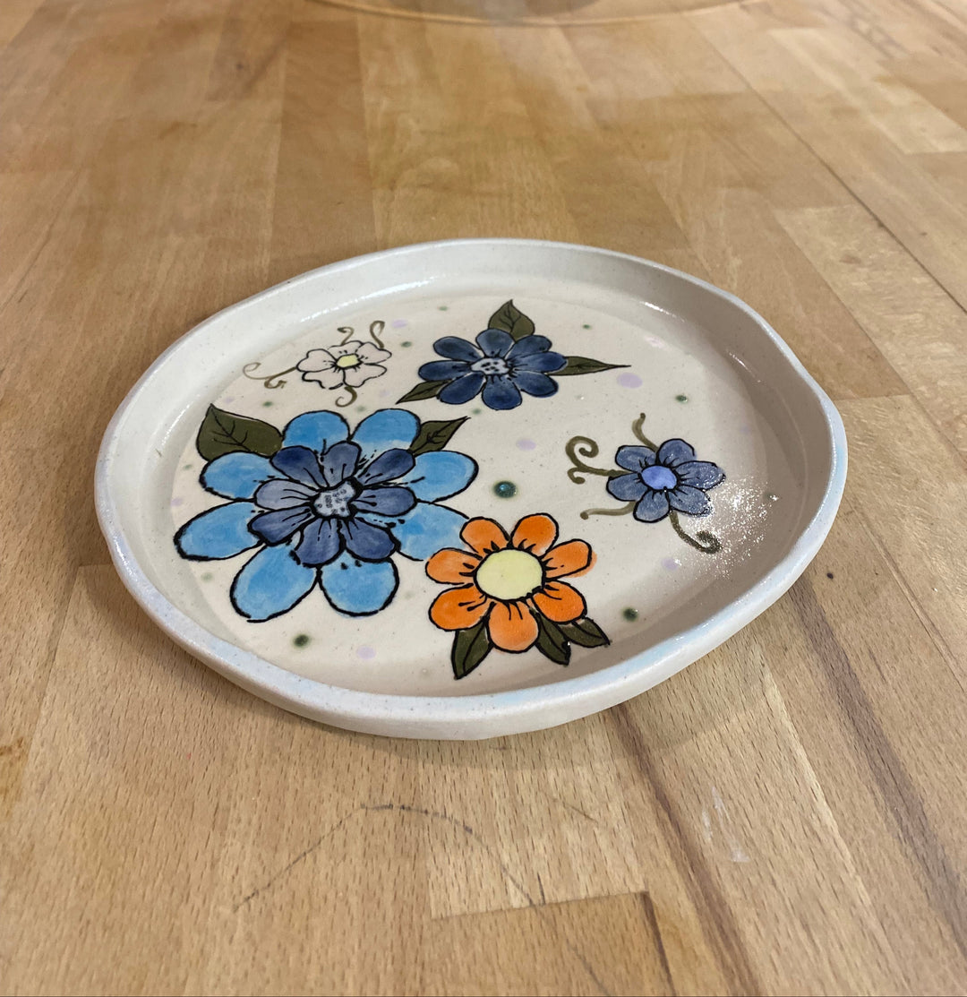 Decorative plate with floral designs on a wooden surface