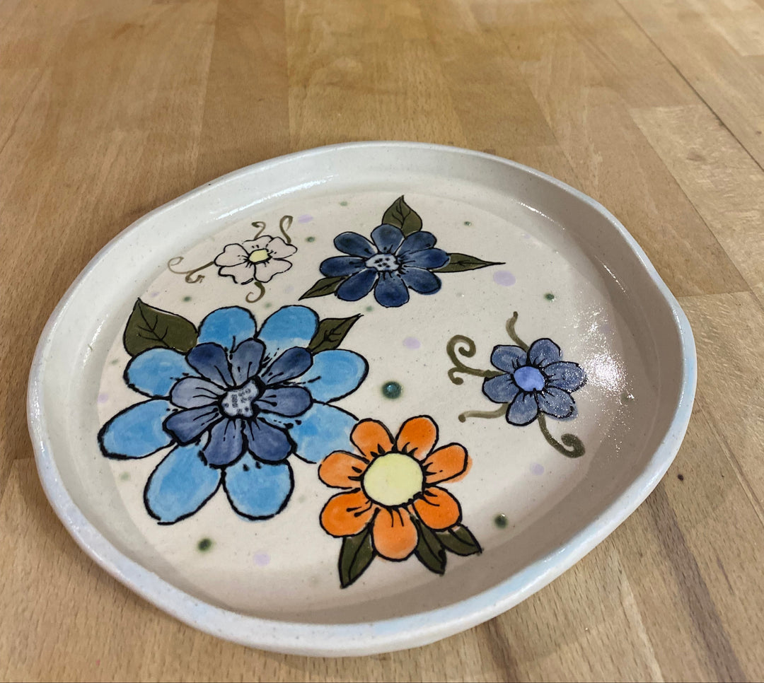 Ceramic plate with floral designs on a wooden surface