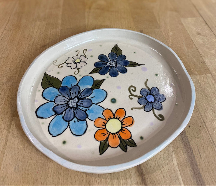 Ceramic plate with floral designs on a wooden surface
