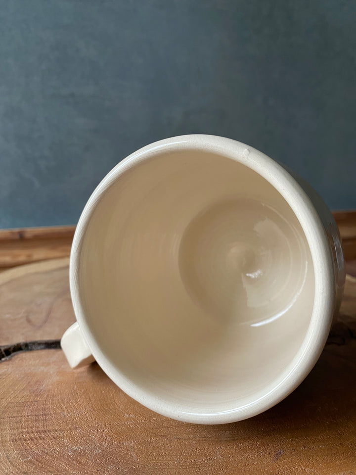 White ceramic mug on a wooden surface with a gray background