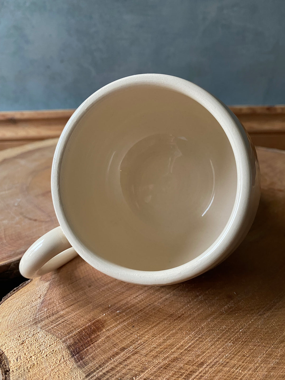 White ceramic mug on a wooden surface with a blurred background