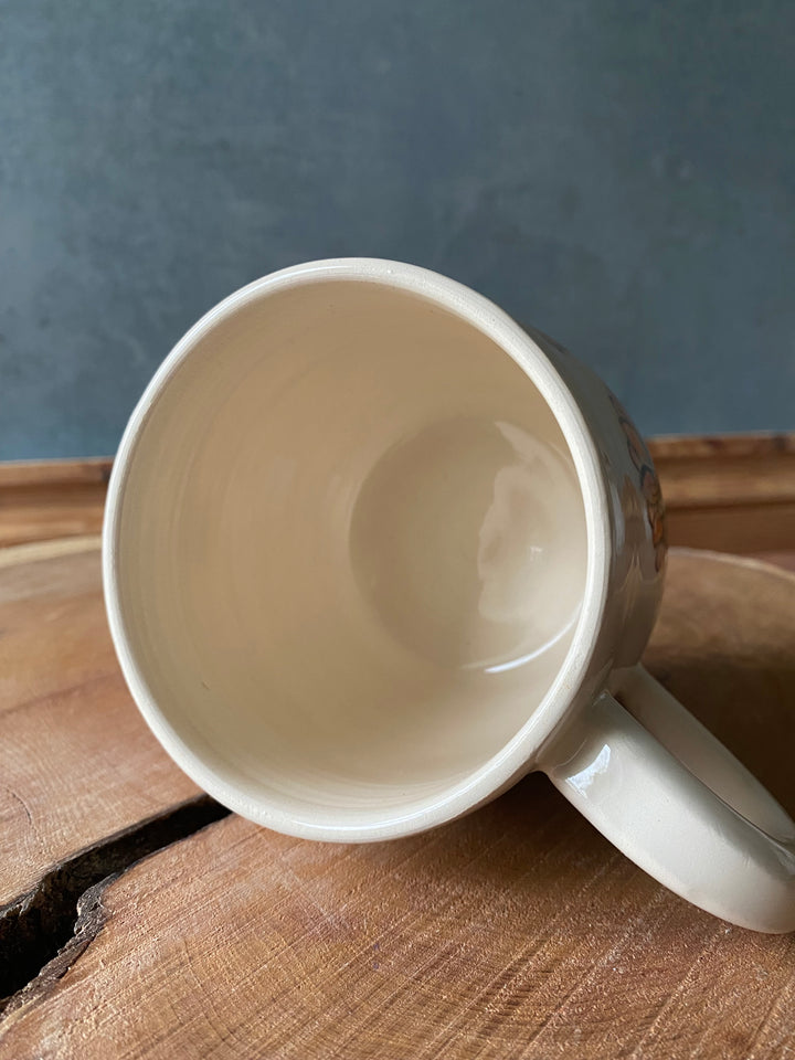 White ceramic mug on a wooden surface with a blue background