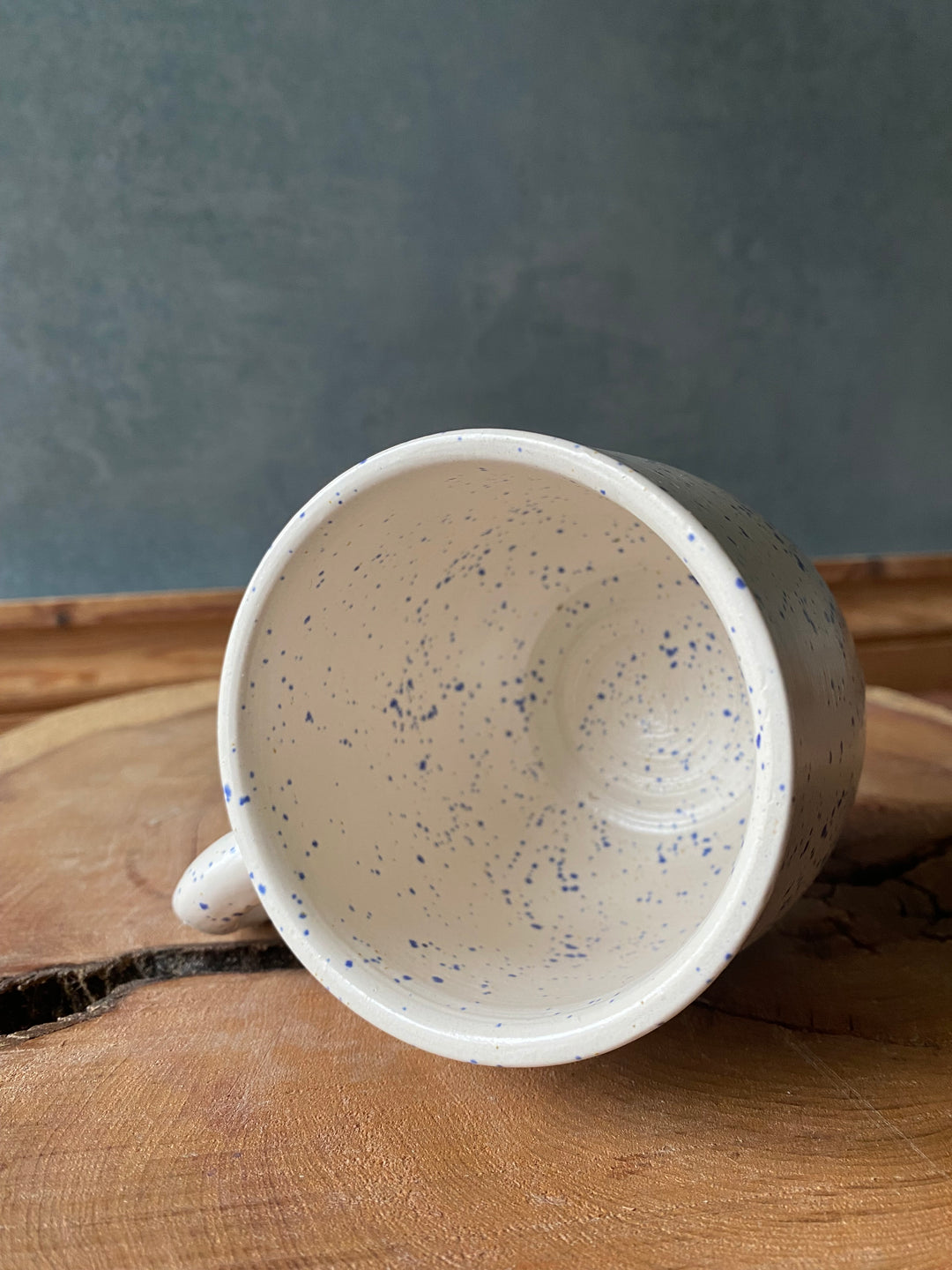 Ceramic mug with speckled interior on a wooden surface
