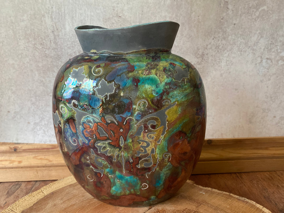 Decorative ceramic vase with multicolored patterns on a wooden surface.
