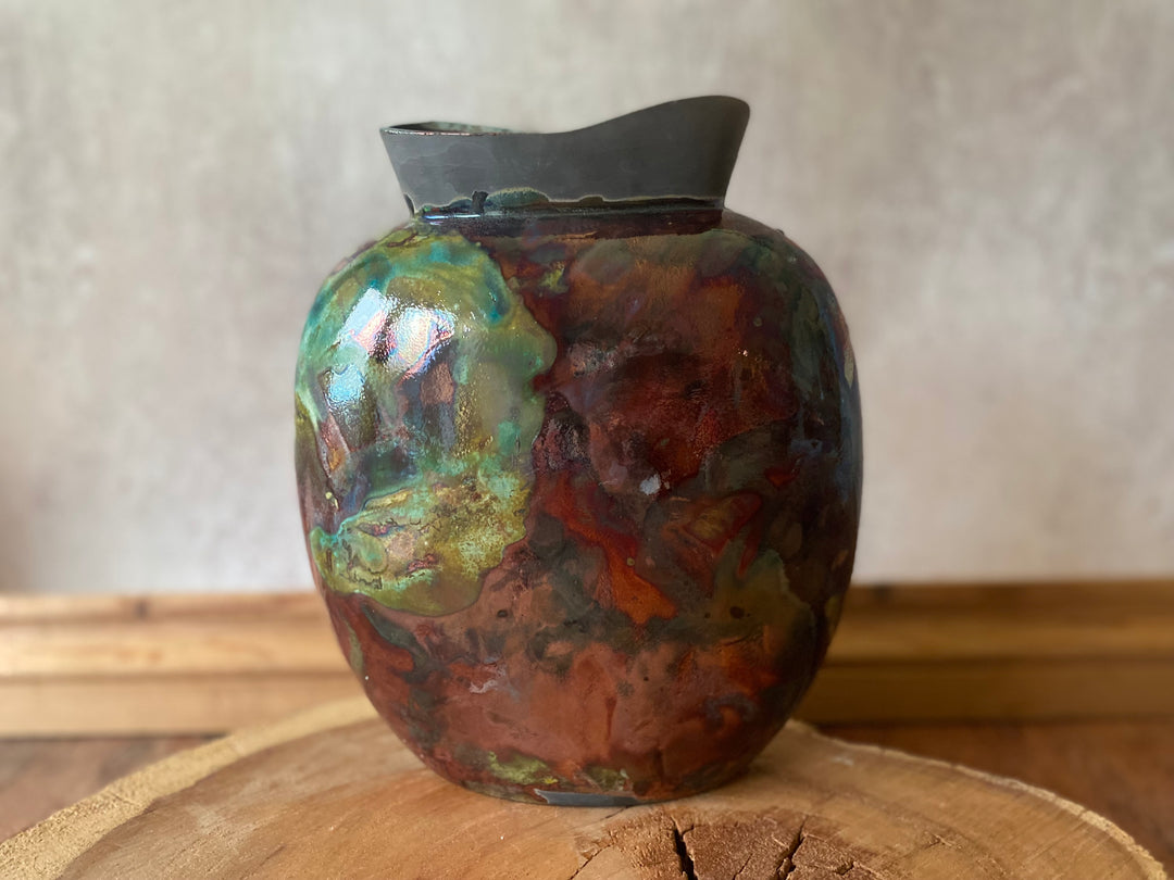 Multicolored ceramic vase on a wooden surface with a neutral background