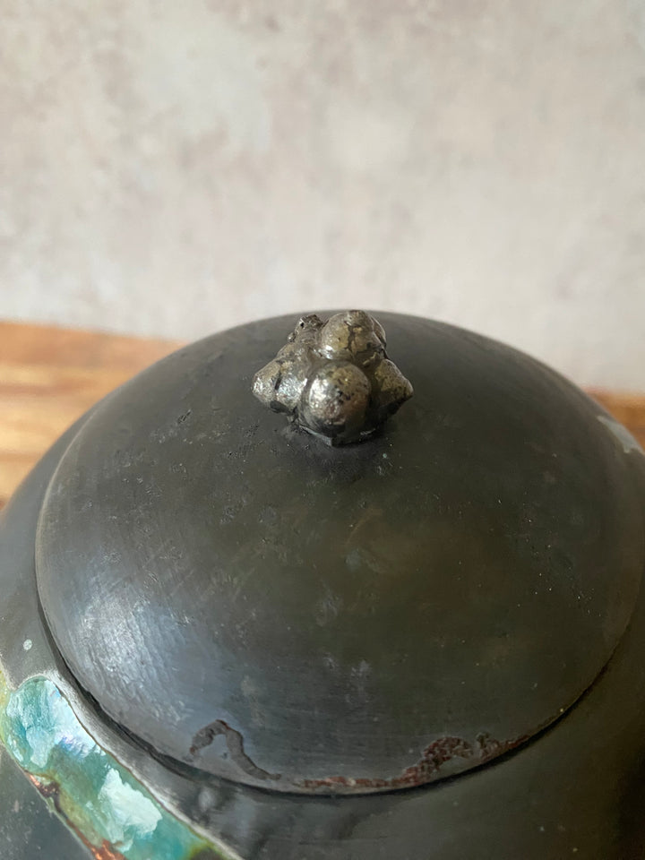 Close-up of a metal object with a bolt on a neutral background