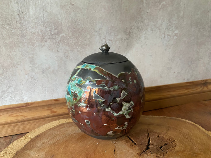 Decorative ceramic jar with a textured surface on a wooden surface with a neutral background