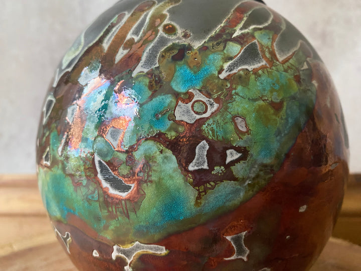 Decorative sphere with multicolored marbled pattern on a neutral background