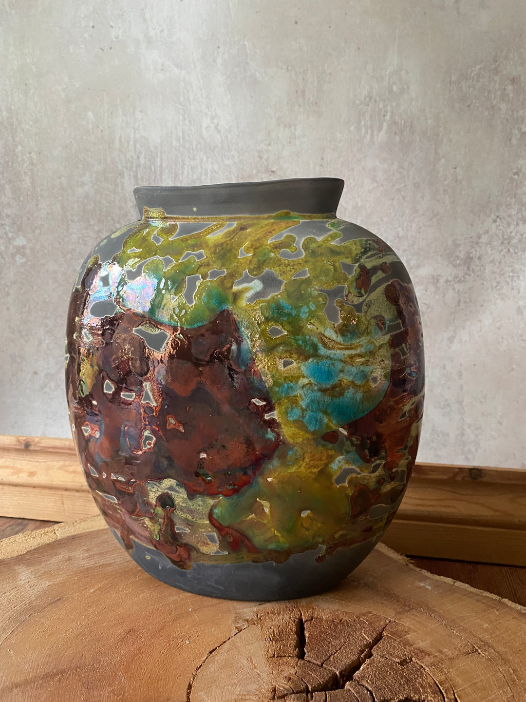 Decorative ceramic vase with multicolored glaze on a textured surface