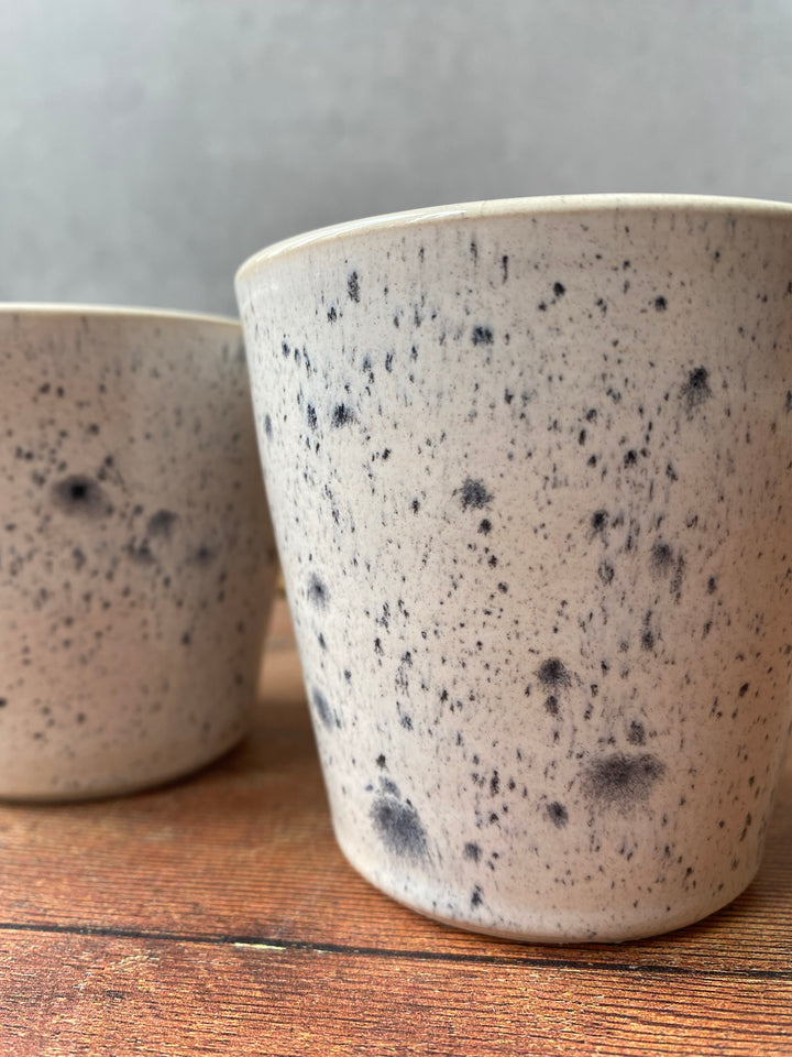 Artisan ink spot white and grey speckled ceramic coffee cup with a flared rim